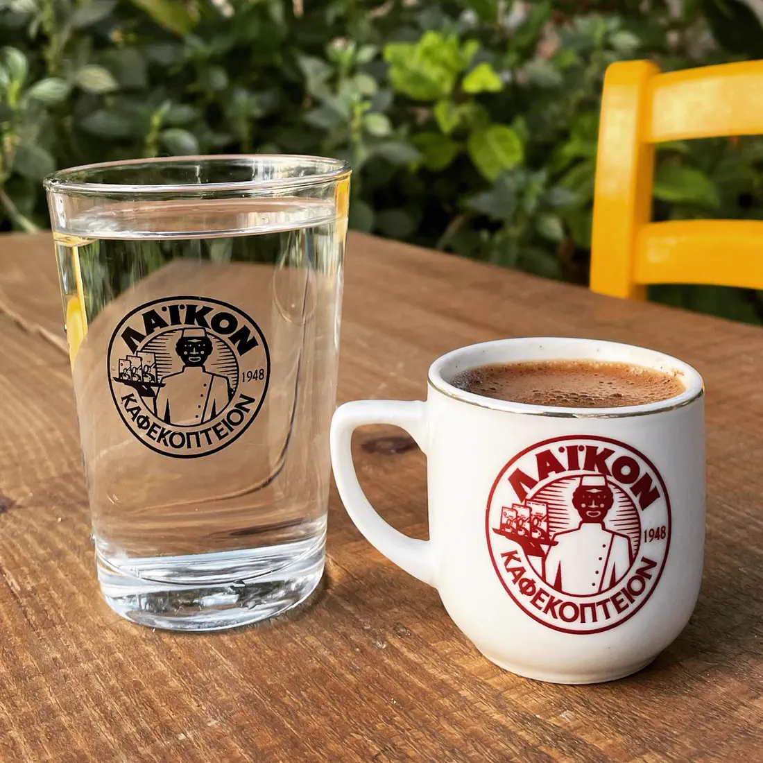 Greek coffee and a glass of water on a wooden table