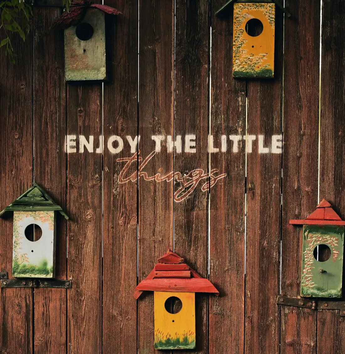 Colourful birdhouses on a wooden fence — enjoy the little things